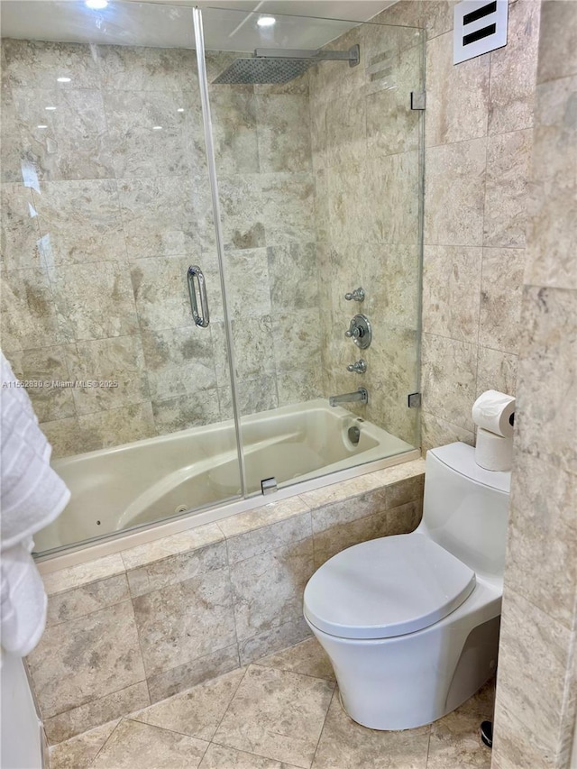 bathroom with toilet, tile walls, and enclosed tub / shower combo