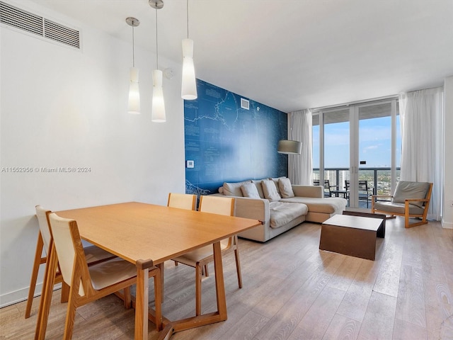 dining space with french doors, expansive windows, and light hardwood / wood-style flooring