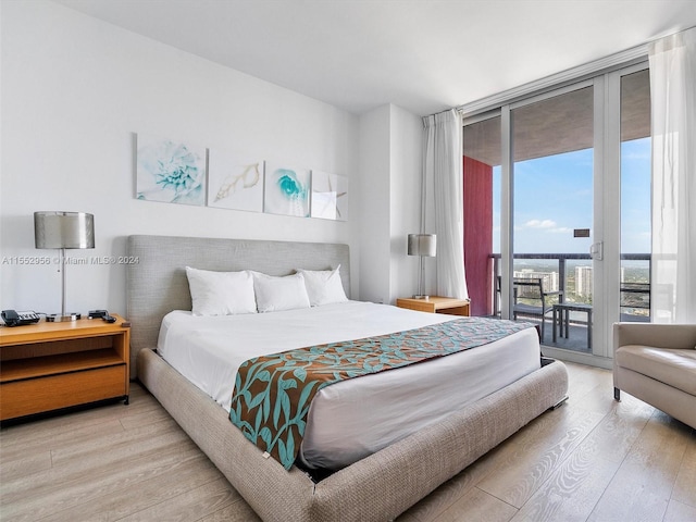 bedroom featuring access to outside, floor to ceiling windows, and light hardwood / wood-style flooring