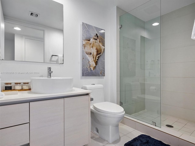 bathroom featuring tile floors, toilet, vanity, and an enclosed shower