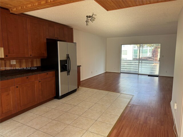 kitchen with wooden ceiling, stainless steel fridge, light hardwood / wood-style flooring, and a textured ceiling