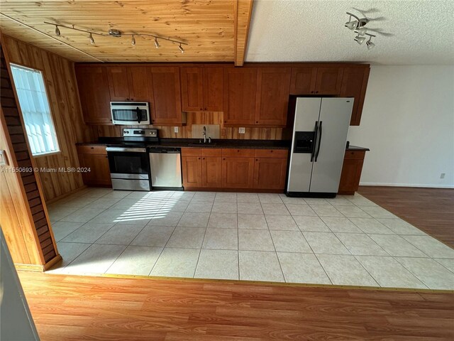 kitchen featuring light tile flooring, wood ceiling, a textured ceiling, sink, and appliances with stainless steel finishes