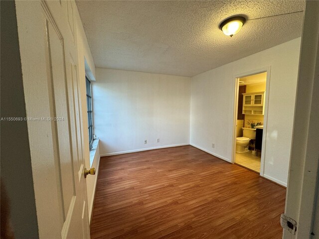 empty room featuring hardwood / wood-style flooring and a textured ceiling