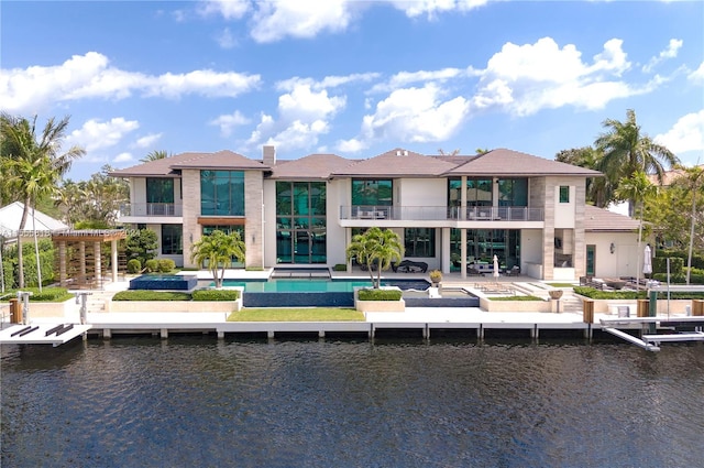 back of house with a balcony, a water view, and a patio area