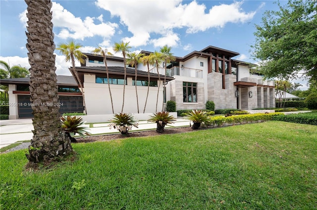 back of house with a balcony and a lawn