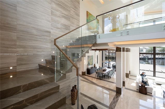 stairs featuring a towering ceiling and a water view