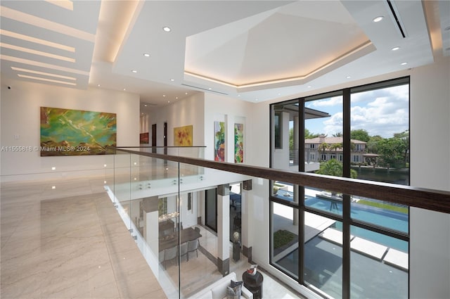 interior space featuring light tile patterned flooring and a tray ceiling