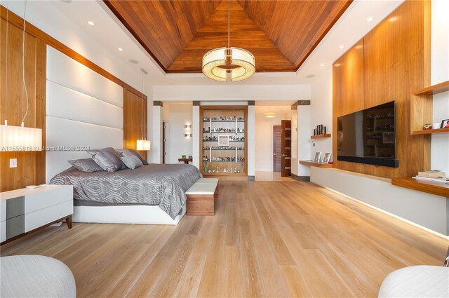 bedroom featuring a tray ceiling, light hardwood / wood-style flooring, and wooden ceiling