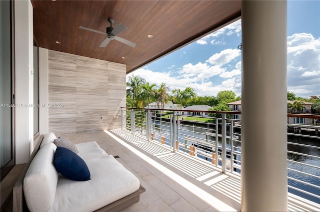 balcony featuring ceiling fan and a water view