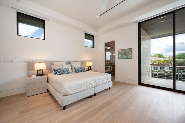 bedroom featuring access to outside, connected bathroom, and light hardwood / wood-style flooring