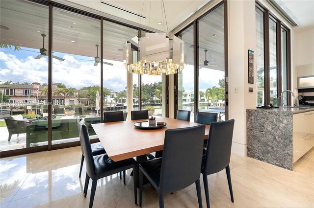 tiled dining room featuring ceiling fan with notable chandelier and sink