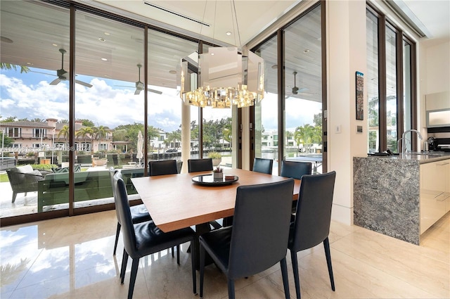 dining room featuring expansive windows, ceiling fan, and sink