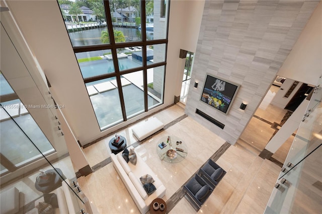 living room with a towering ceiling and a tile fireplace