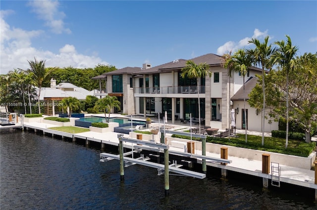 back of property featuring a water view, a balcony, and a patio