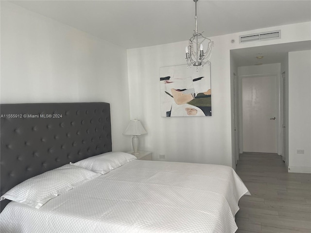801 Brickell Key Blvd Unit 1610, Miami, FL 33131 - bedroom featuring wood finished floors and a chandelier