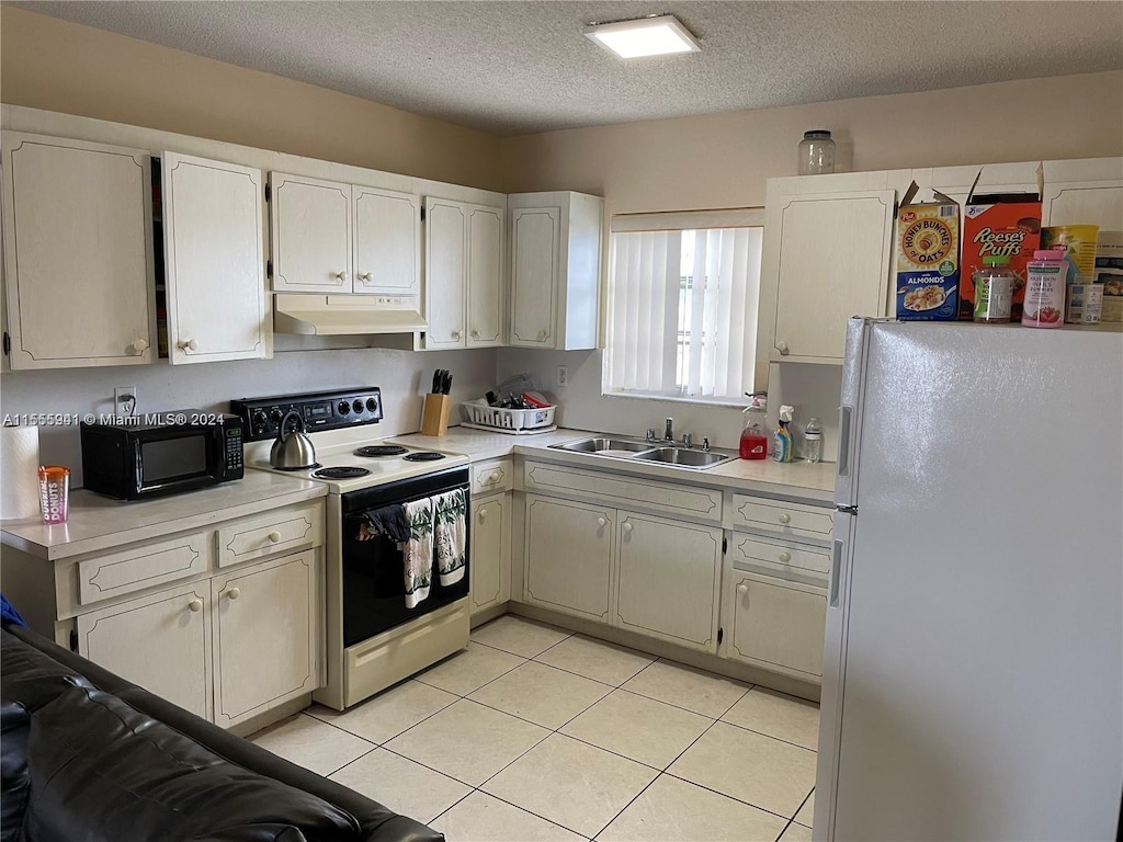 kitchen with a textured ceiling, white appliances, sink, and light tile patterned floors