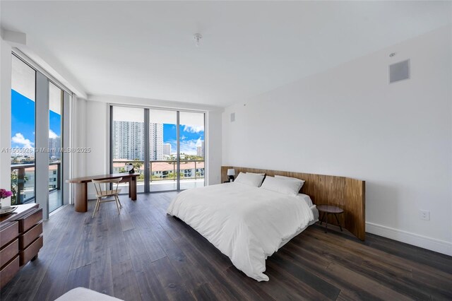 dining space with floor to ceiling windows, a healthy amount of sunlight, hardwood / wood-style floors, and a water view