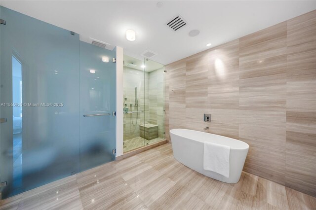 bedroom with hardwood / wood-style floors, access to outside, expansive windows, and a water view