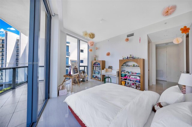 bedroom with tile patterned flooring, floor to ceiling windows, access to outside, and a water view