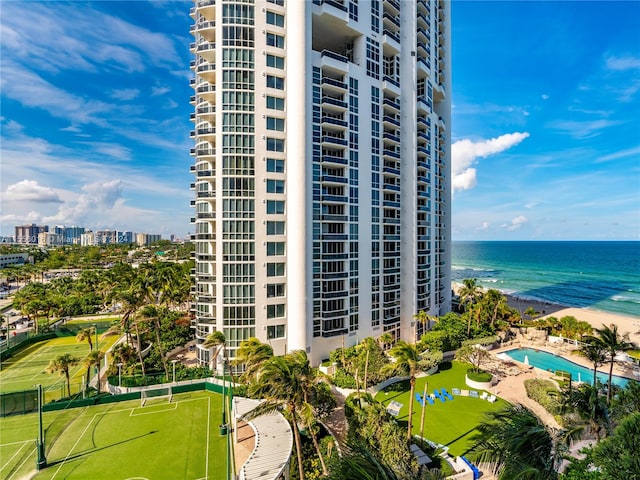 view of building exterior with a beach view and a water view