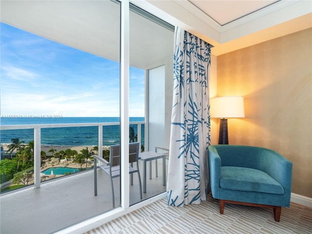 sitting room with ornamental molding, a water view, and carpet flooring