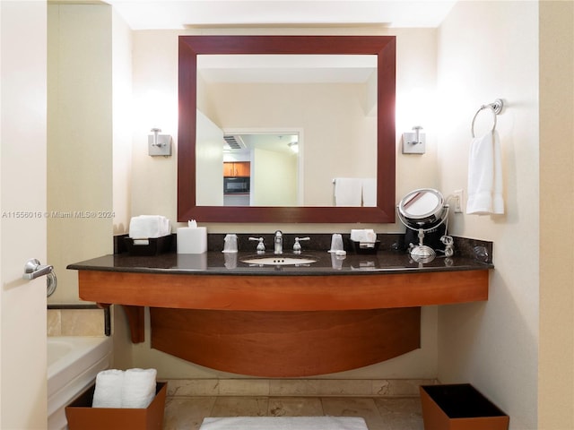 bathroom featuring tile patterned flooring, a bathtub, and vanity