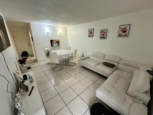 tiled living room featuring a textured ceiling