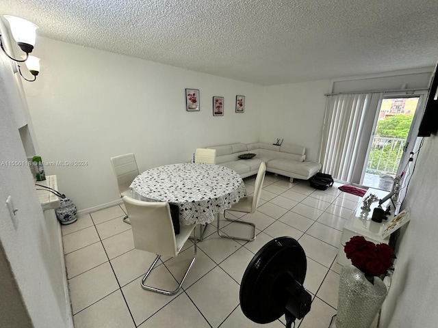 tiled dining area featuring a textured ceiling