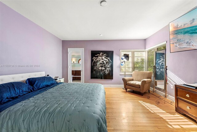 bedroom with light hardwood / wood-style flooring and ensuite bathroom