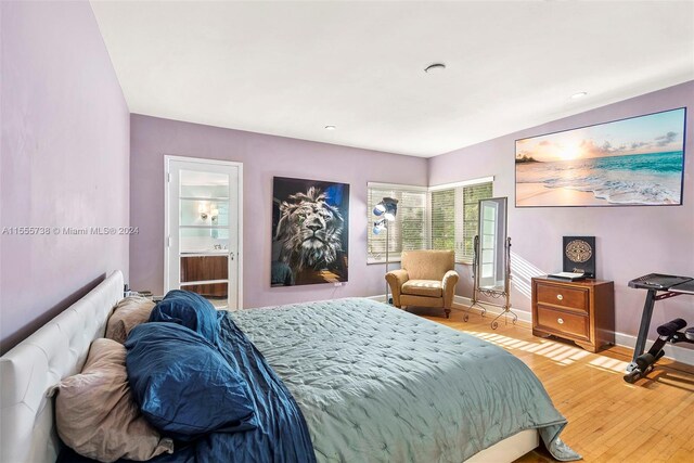 bedroom featuring ensuite bathroom and light hardwood / wood-style floors