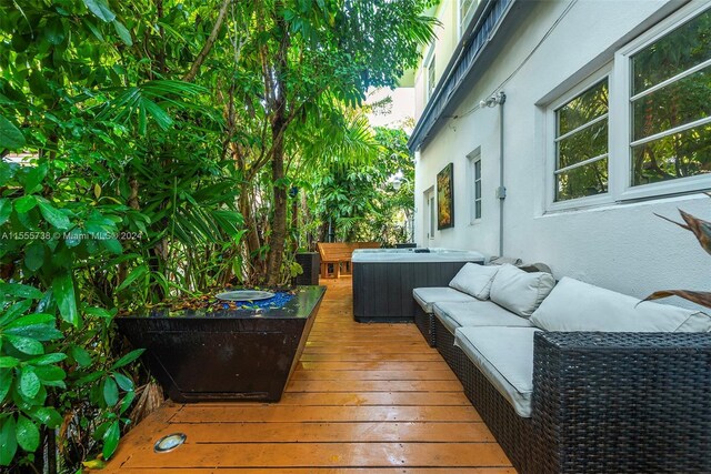 wooden terrace with an outdoor living space, central air condition unit, and a hot tub