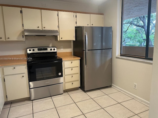 kitchen with white cabinetry, light tile patterned floors, and stainless steel appliances