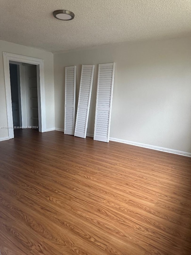 unfurnished bedroom with hardwood / wood-style floors and a textured ceiling