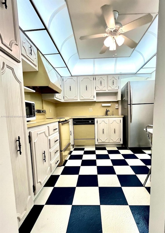 kitchen featuring stainless steel appliances, dark tile floors, ceiling fan, and sink