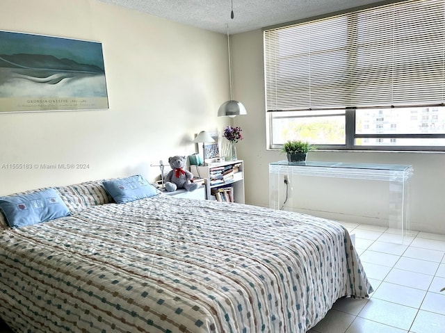 bedroom with a textured ceiling and light tile flooring