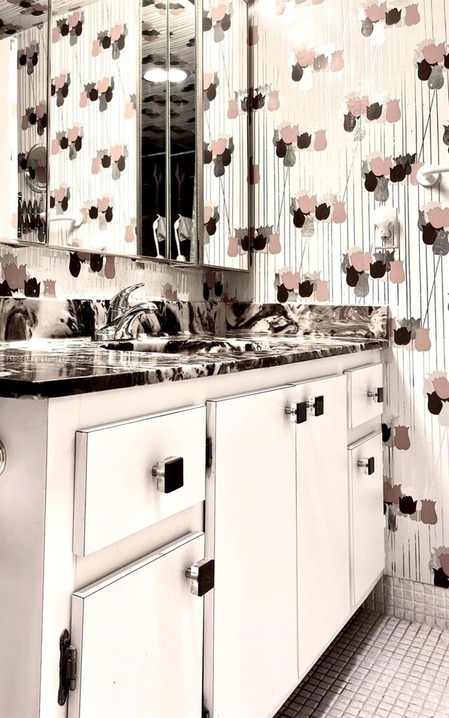 kitchen with tile floors and white cabinetry