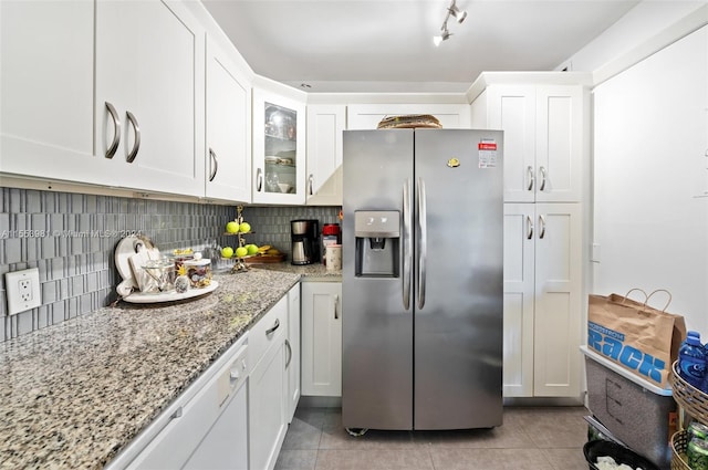 kitchen with white cabinets, stainless steel fridge with ice dispenser, tasteful backsplash, and light stone countertops