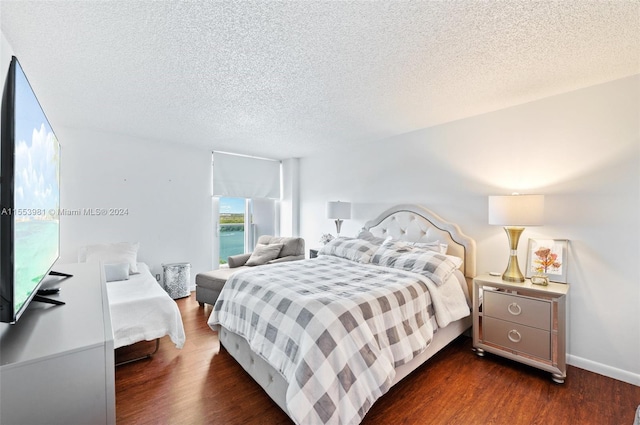 bedroom with dark hardwood / wood-style flooring and a textured ceiling