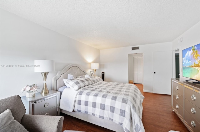 bedroom featuring dark hardwood / wood-style floors and a textured ceiling