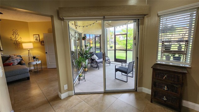 doorway to outside with light tile patterned floors