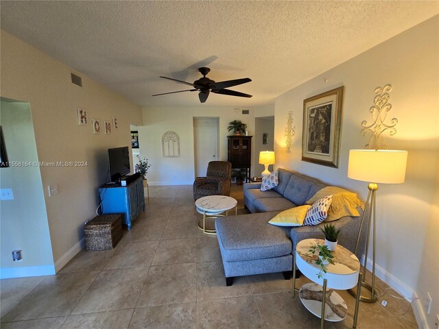 living room featuring a textured ceiling and ceiling fan