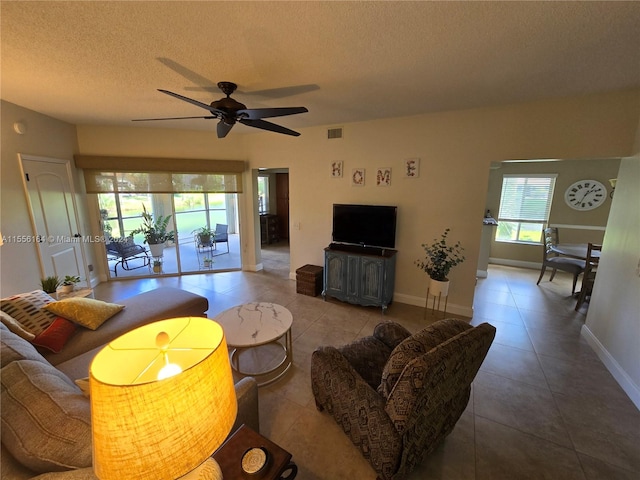 living room featuring tile patterned floors, ceiling fan, and a textured ceiling