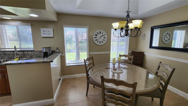 tiled dining area featuring a textured ceiling, a notable chandelier, and sink