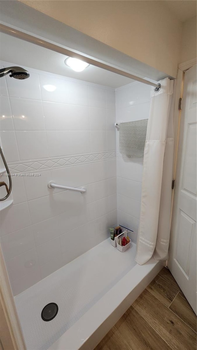 bathroom with a shower with curtain and wood-type flooring