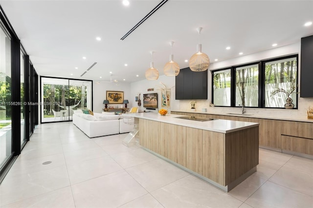 kitchen with a kitchen island, black electric cooktop, a wall of windows, and tasteful backsplash