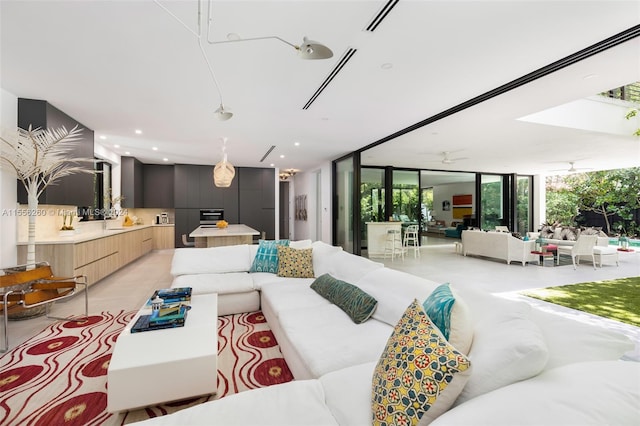 living room with a wall of windows, ceiling fan, and a wealth of natural light