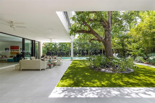 view of yard with ceiling fan, an outdoor hangout area, and a patio area