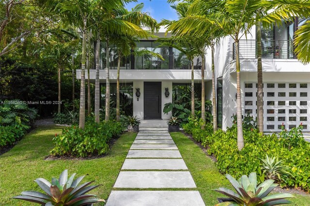 view of exterior entry with a lawn and a garage