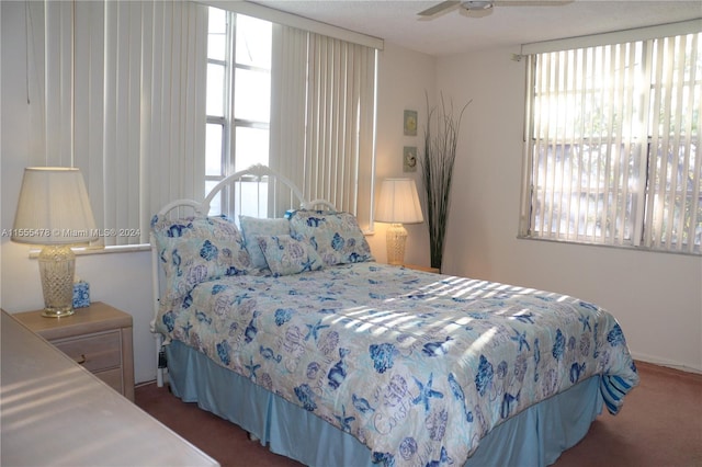 carpeted bedroom featuring ceiling fan and multiple windows