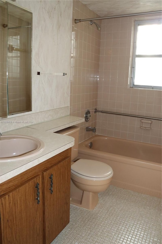 full bathroom featuring tile patterned floors, vanity, toilet, and tiled shower / bath